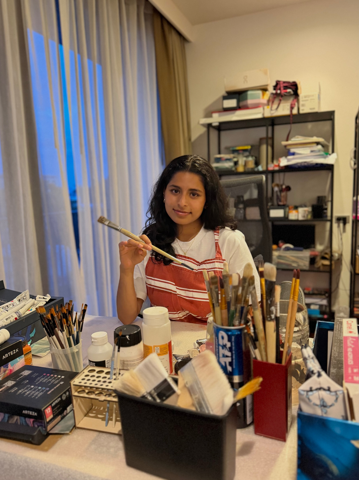 Sania in her studio holding a paintbrush